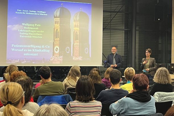 Wolfgang Putz (li.), Rechtsanwalt und Medizinrechtler, setzt sich seit vielen Jahren für einen gelungenen Umgang mit dem Patientenwillen am Lebensende ein. In Rosenheim berichtete er von seinen Erfahrungen und schilderte eindrückliche Fälle, die Patienten, Angehörigen und Behandelnden gleichermaßen viel abverlangen. Anja Müller (re.) vom Ethikkomitee RoMed Rosenheim begrüßte die Anwesenden, darunter viele RoMed-Mitarbeitende wie auch externe Teilnehmende.